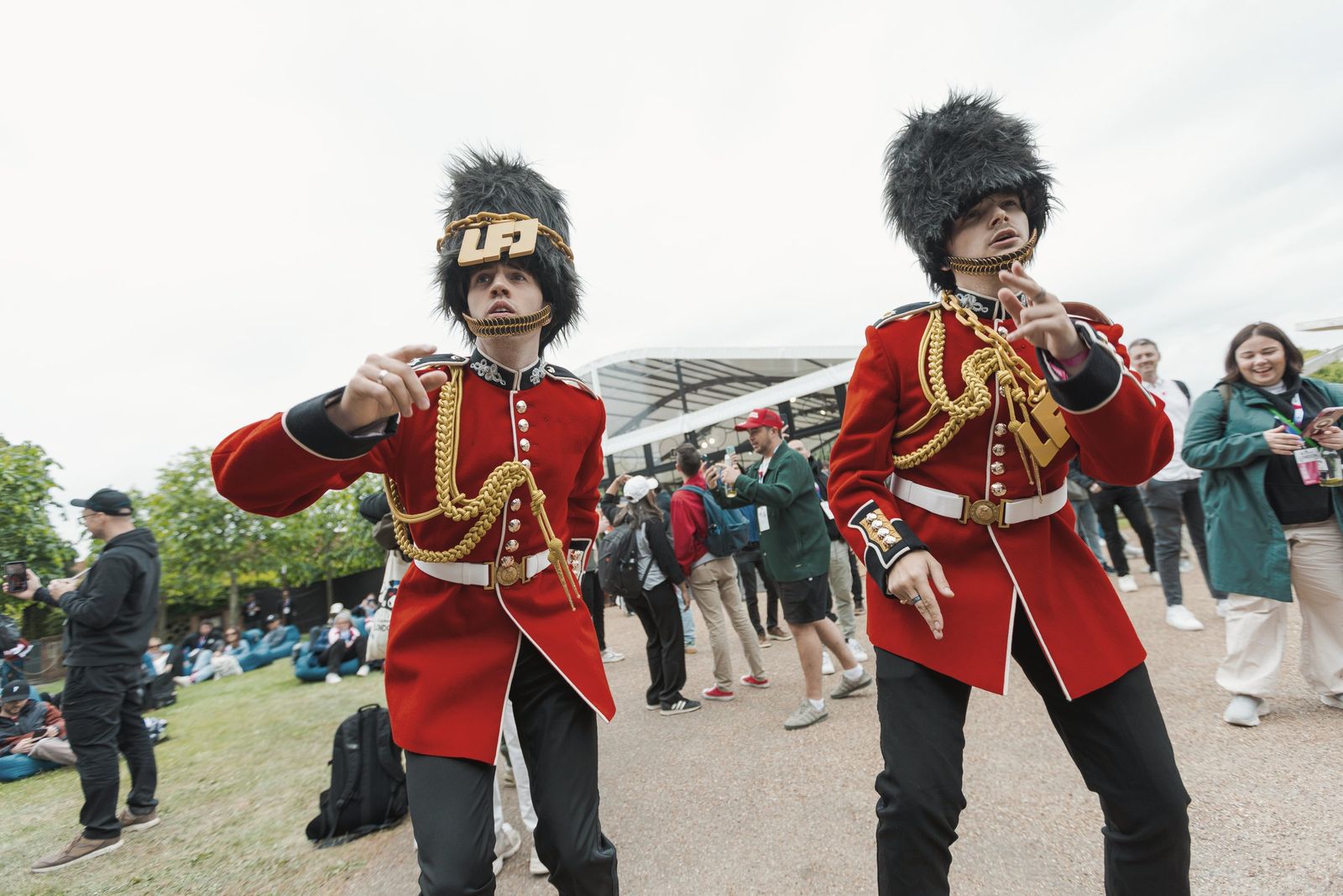 Two performers dressed as King’s Guards in bearskin hats and red tunics, posing on the lawn at Hatfield House